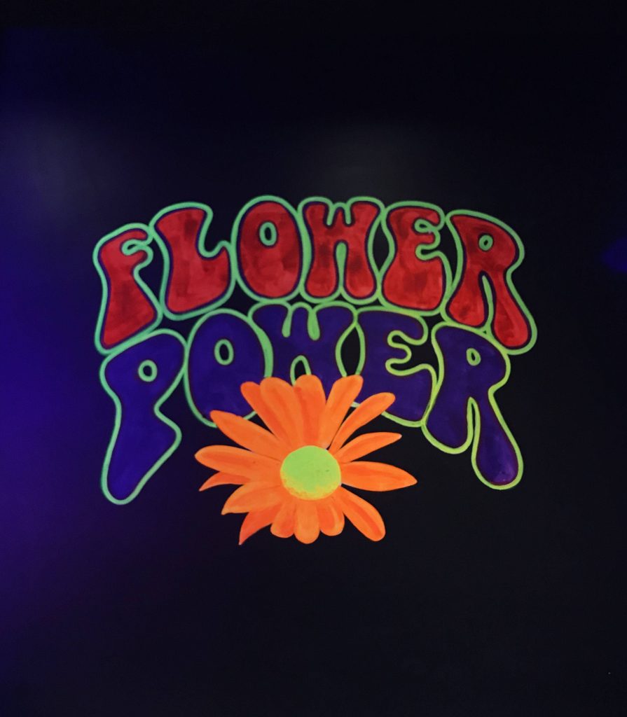 Flower Power neon 1960s hippie wallpaper with vibrant orange daisy on dark psychedelic background