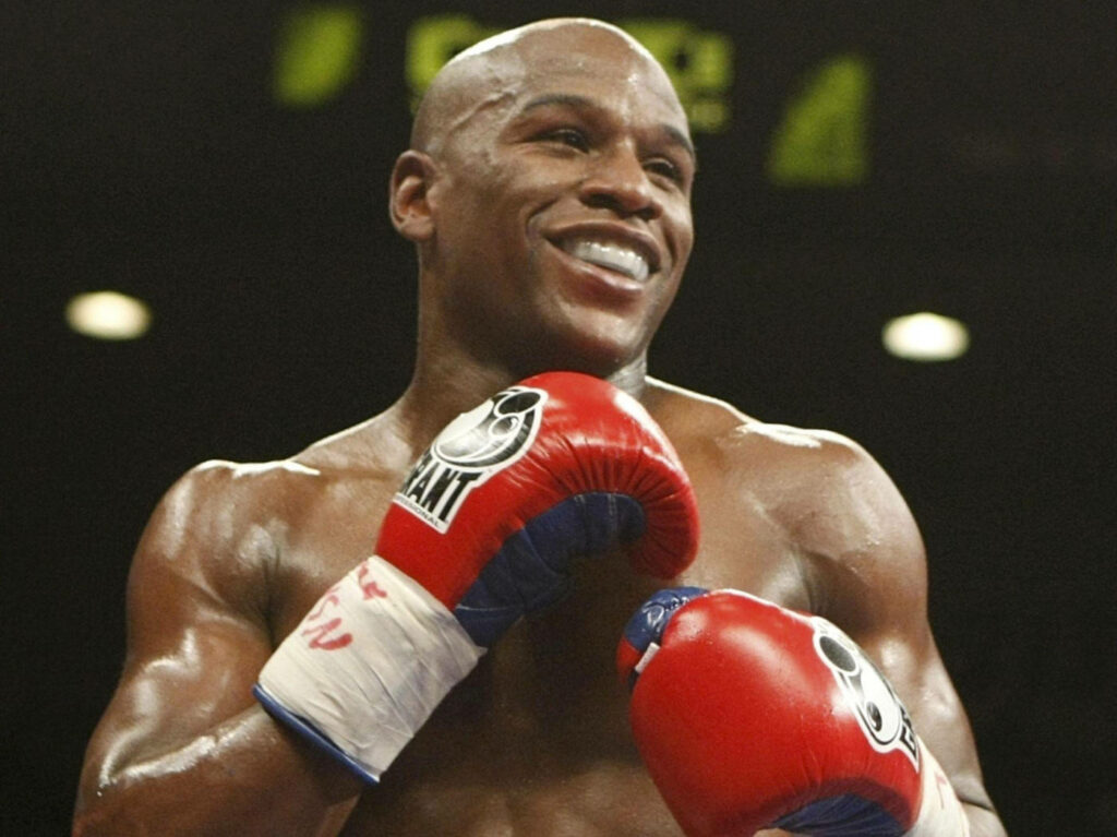 Floyd Mayweather: Confident Smiles in Red Gloves Wallpaper Background