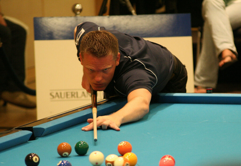 Billiards player aiming with pool cue on blue table preparing to break colorful balls rack Wallpaper