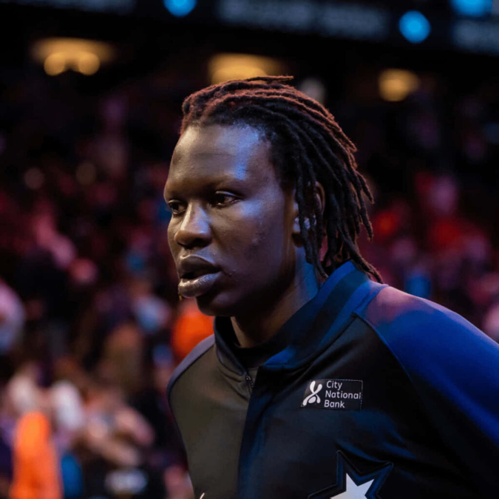 Close-up of Bol Bol basketball player intense focused profile with vibrant court background wallpaper