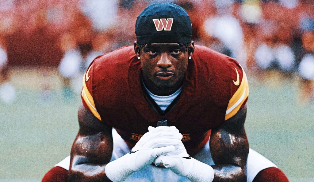 Focused Brian Robinson Jr football wallpaper red gold uniform intense game day preparation