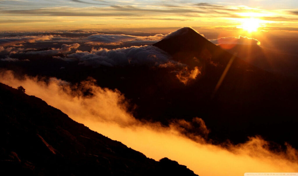 Majestic Acatenango Volcano Engulfed in Enchanting Sunset Haze - A Captivating Snapshot of Guatemala's Scenic Beauty Wallpaper