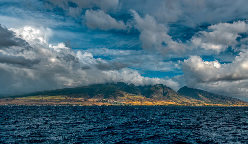 Rugged foggy mountains green slopes meet deep blue sea dramatic cloudy sky landscape wallpaper