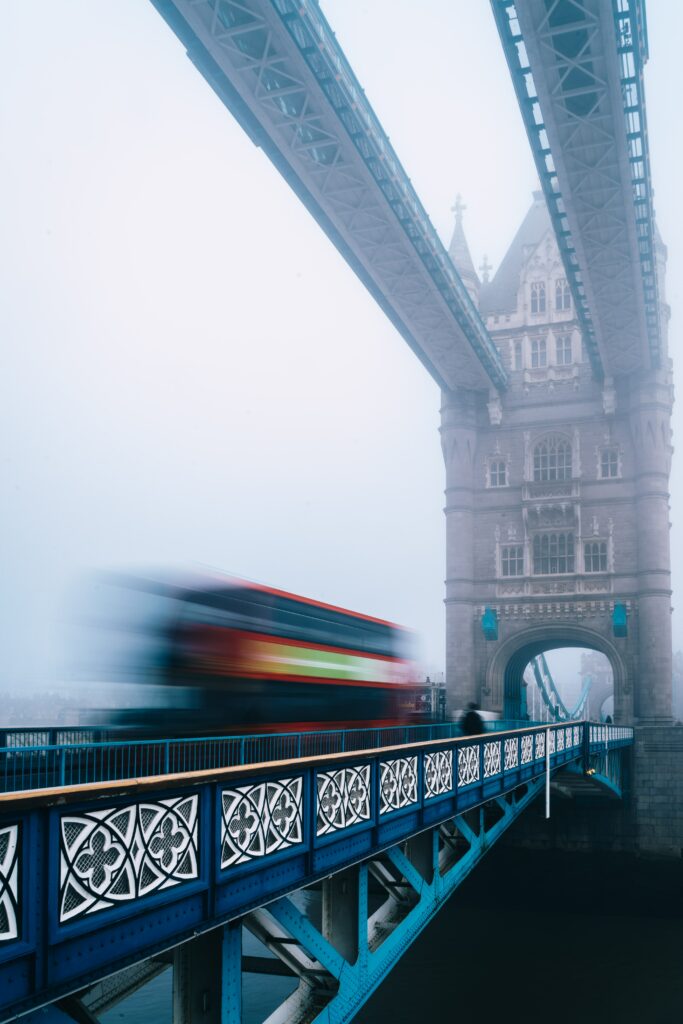 Foggy Urban Wallpaper: Iconic Bridge & Double-Decker Bus Motion