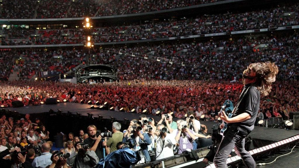 Foo Fighters live concert wallpaper Dave Grohl headbanging on stage with crowd and photographers