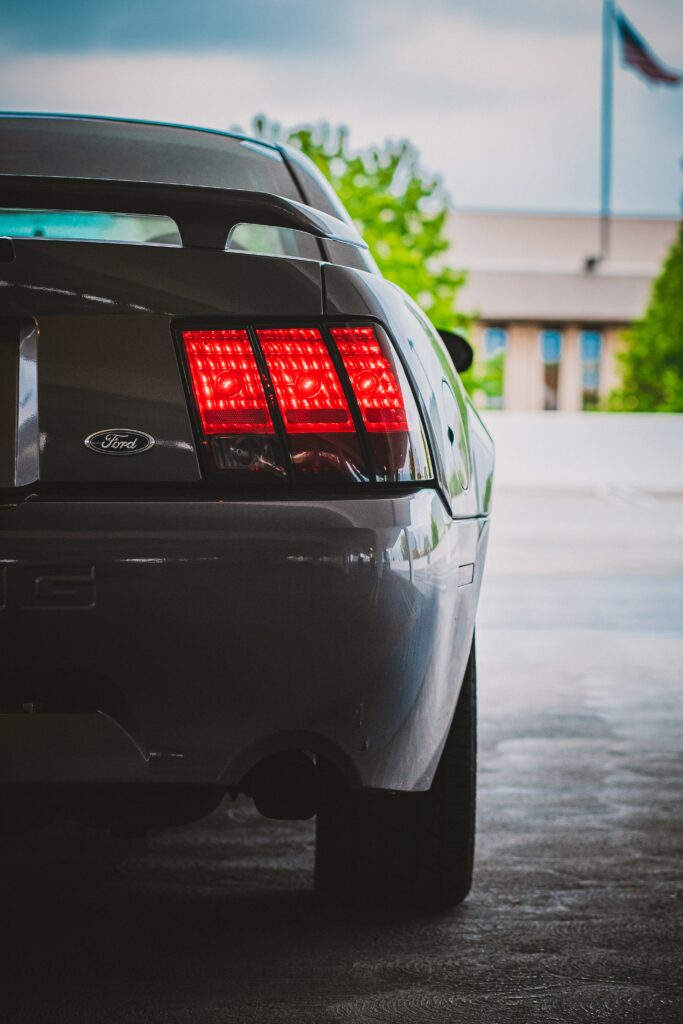 Elegant Ford Car Rear View with Illuminated Taillights in Urban Setting Wallpaper