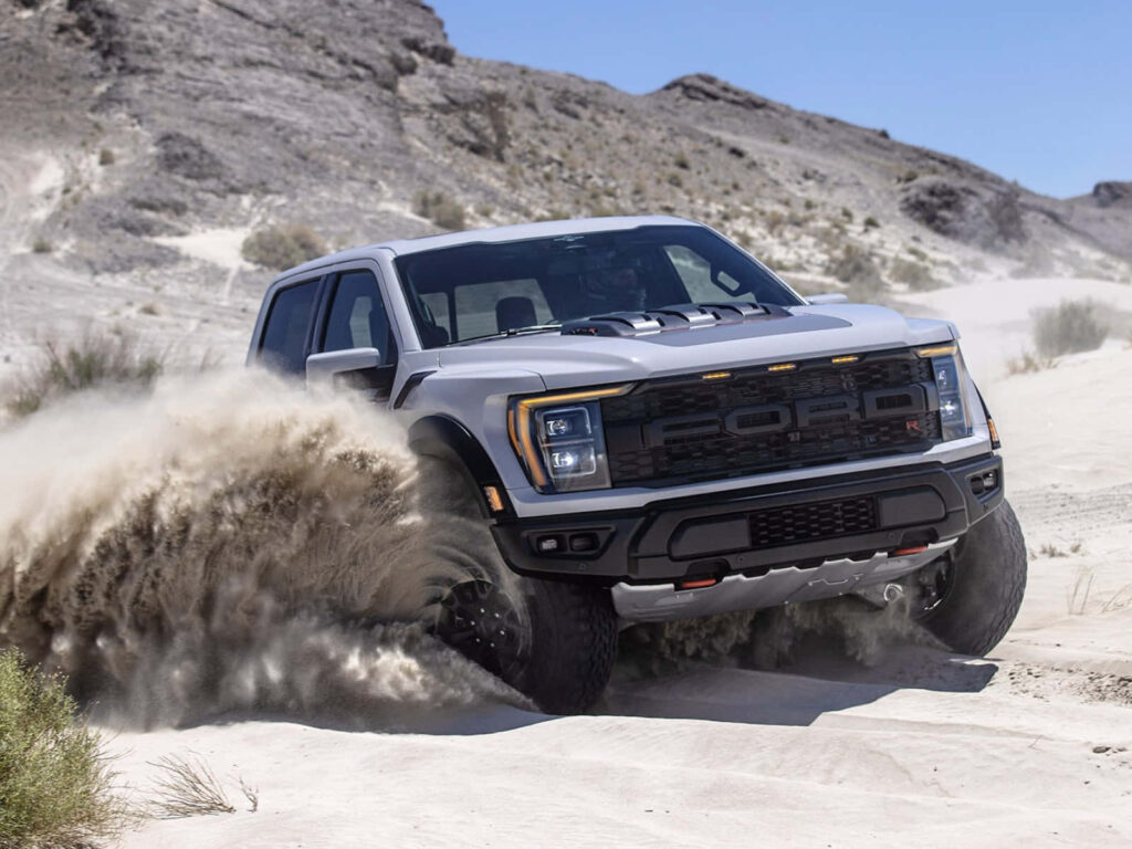 Ford F150 driving fast in sandy desert showcasing rugged off-road power and durability wallpaper