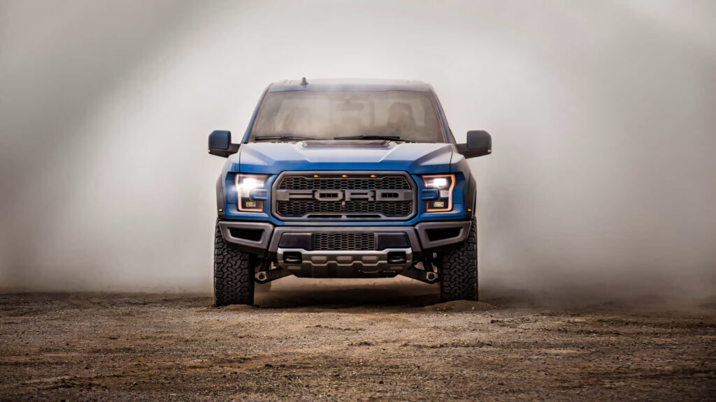 Ford F-150 truck head-on with rugged dusty background showcasing bold design and adventure Wallpaper