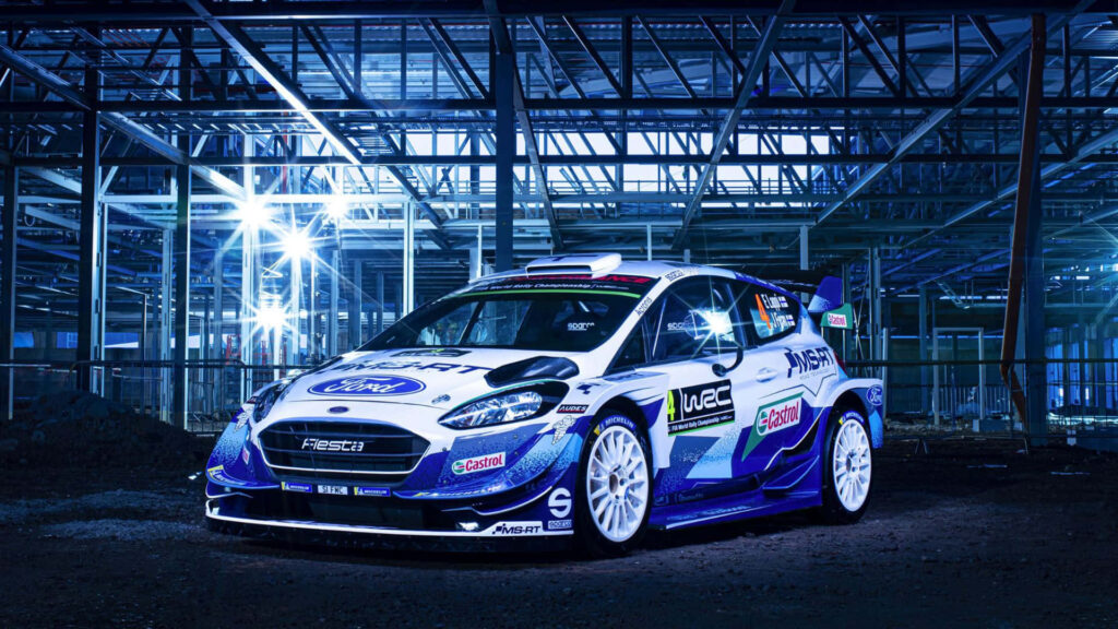 Ford Fiesta rally car in blue lighting against industrial steel framework wallpaper background