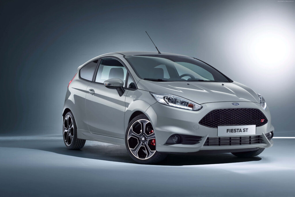 Ford Fiesta ST in vibrant red showcasing sporty design and modern features on smooth background Wallpaper