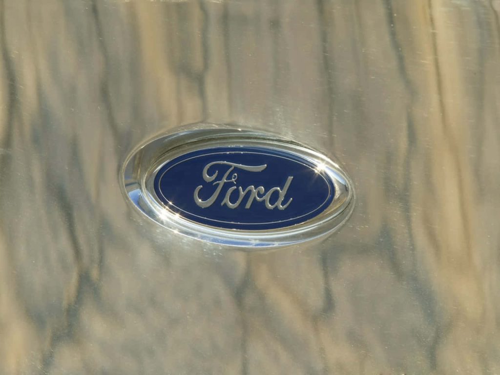 Close-up of Ford logo on polished brushed chrome surface with bright reflections car wallpaper
