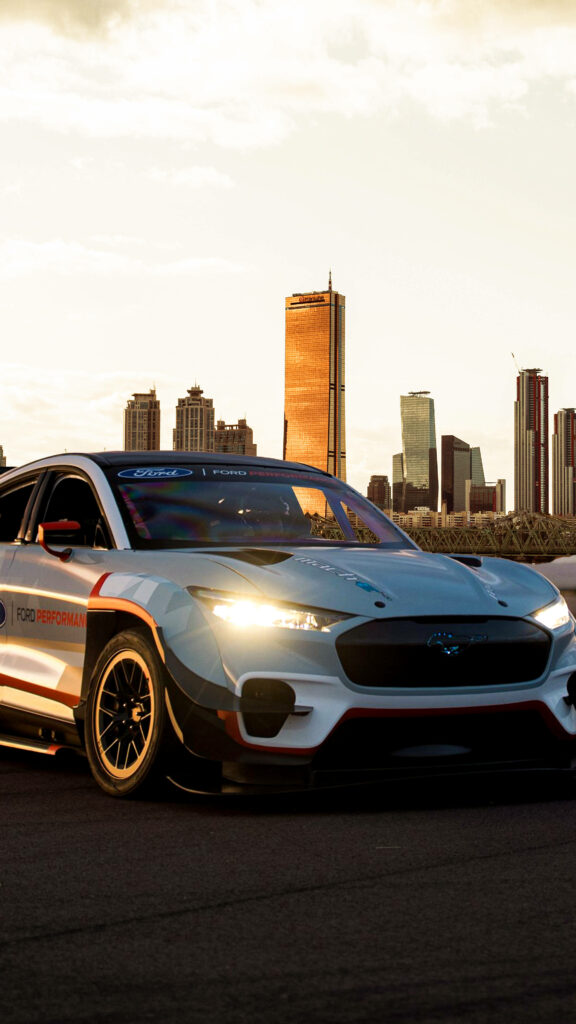 Sleek Ford Performance car parked cityscape sunset skyscrapers golden light 4K wallpaper