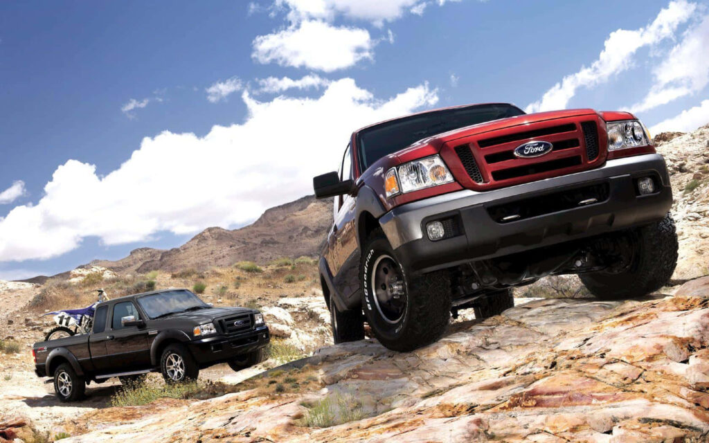 Ford Ranger truck conquering rugged terrain under bright sky showcasing strength and adventure Wallpaper