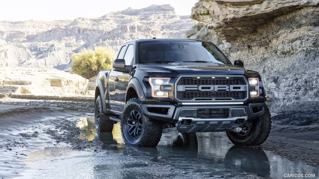 Ford truck conquers rugged desert terrain with off-road power crossing rocky shallow water Wallpaper