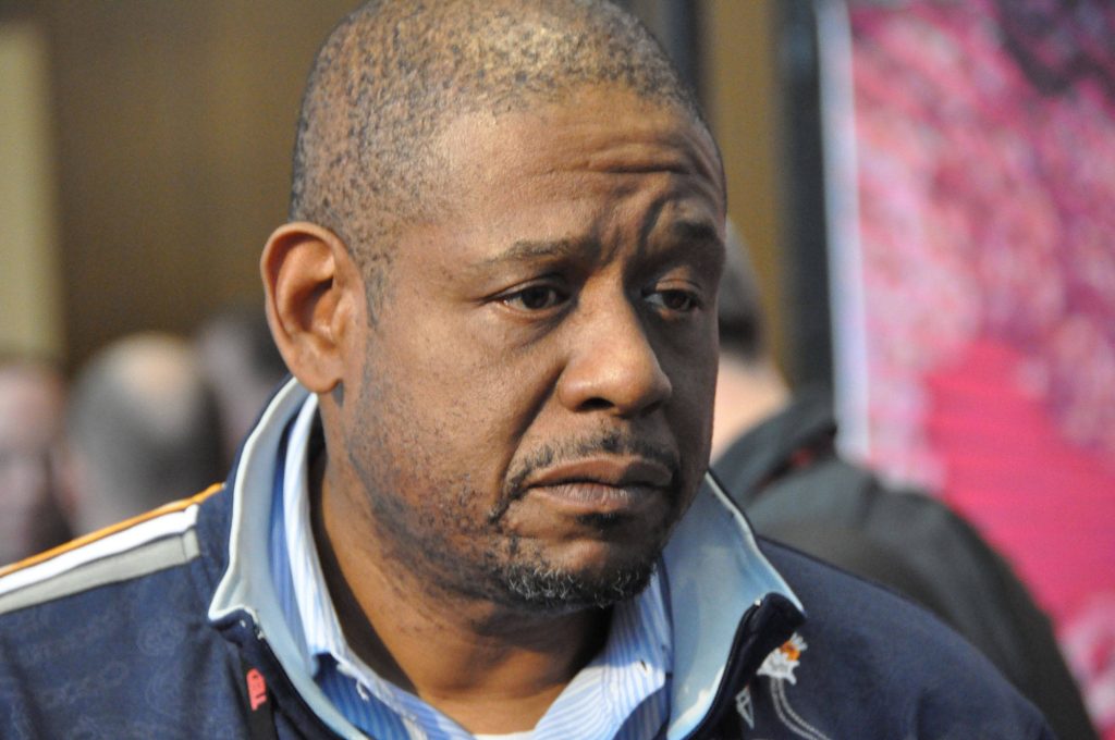 Forest Whitaker in blue jacket and striped shirt with serious expression soft indoor lighting Wallpaper