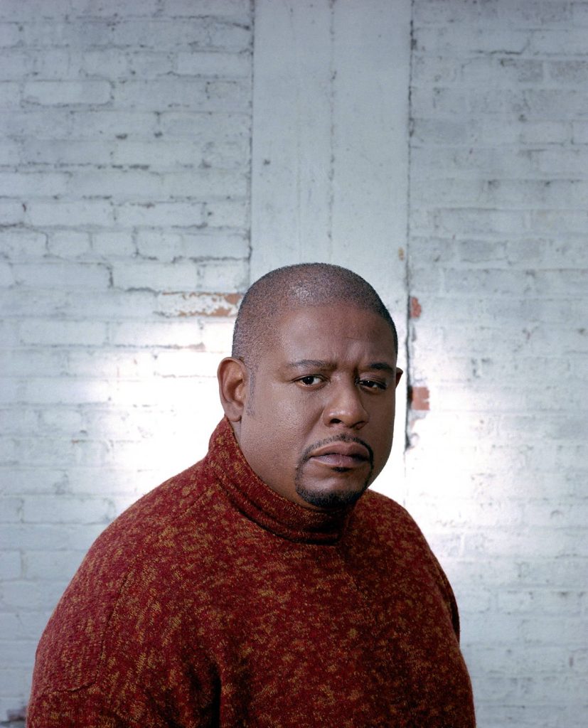 Forest Whitaker professional portrait in reddish-brown turtleneck against white brick wall background Wallpaper