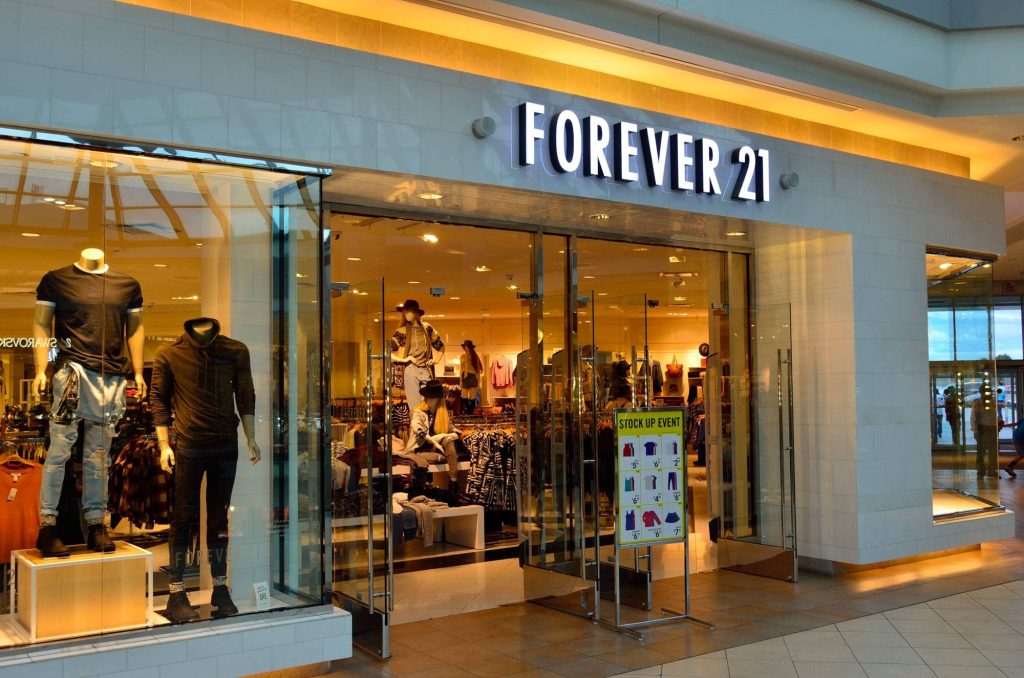 Forever 21 storefront with trendy mannequins glass doors and Stock Up Event signage Wallpaper
