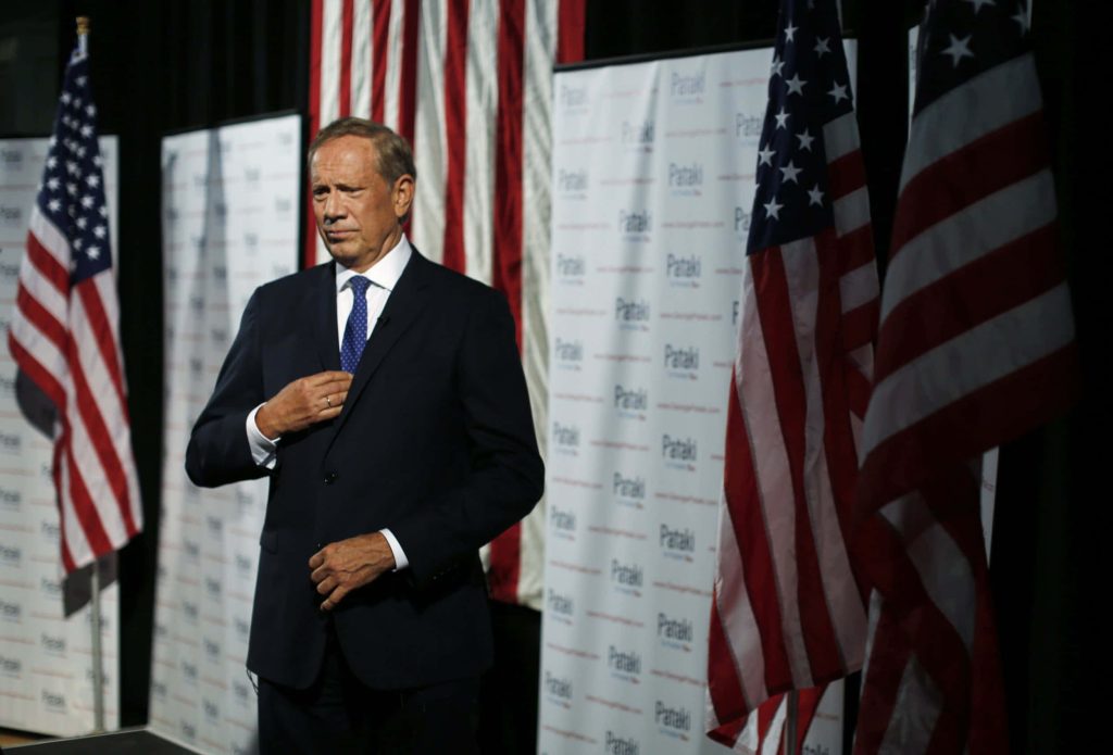 Former Governor George Pataki in suit with American flags and campaign banners political portrait Wallpaper