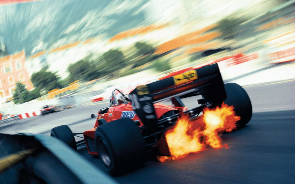 Formula 1 car speeding through corner with bright exhaust flames and blurred city background wallpaper