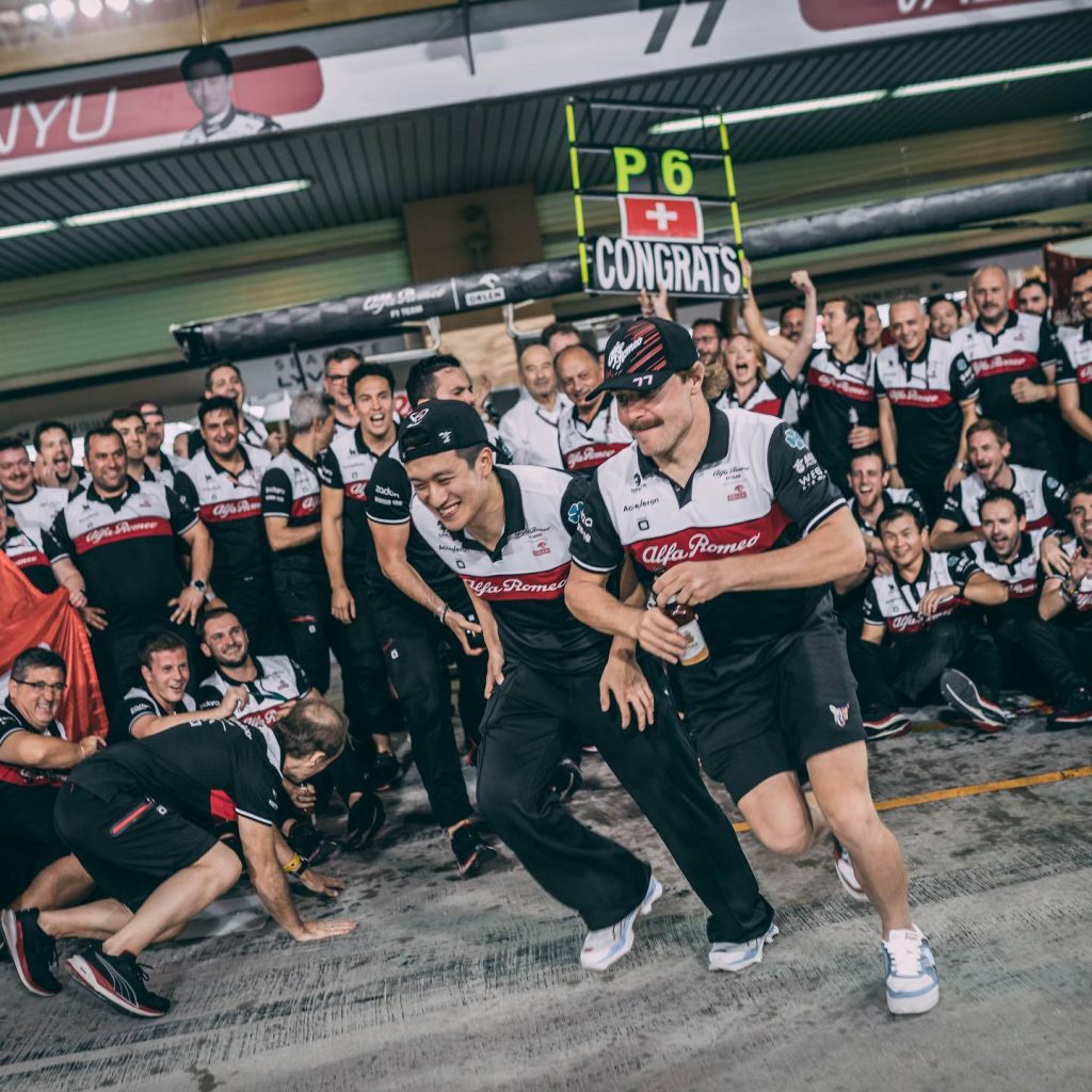 Formula 1 drivers Zhou Guanyu and Valtteri Bottas celebrate P6 finish in Alfa Romeo pit garage Wallpaper