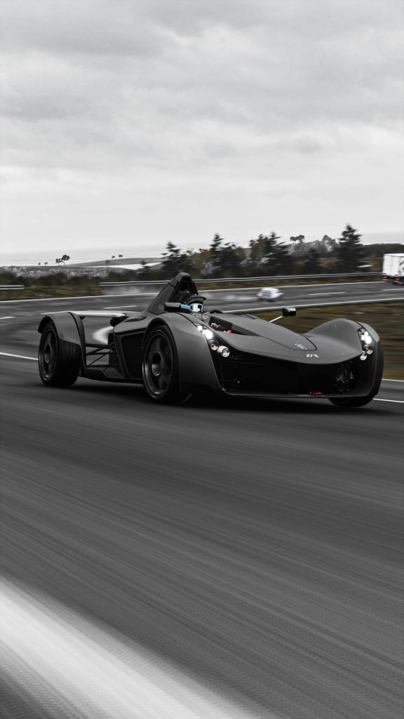 BAC Mono black supercar in motion blur on winding road under cloudy skies Forza Horizon 4 wallpaper