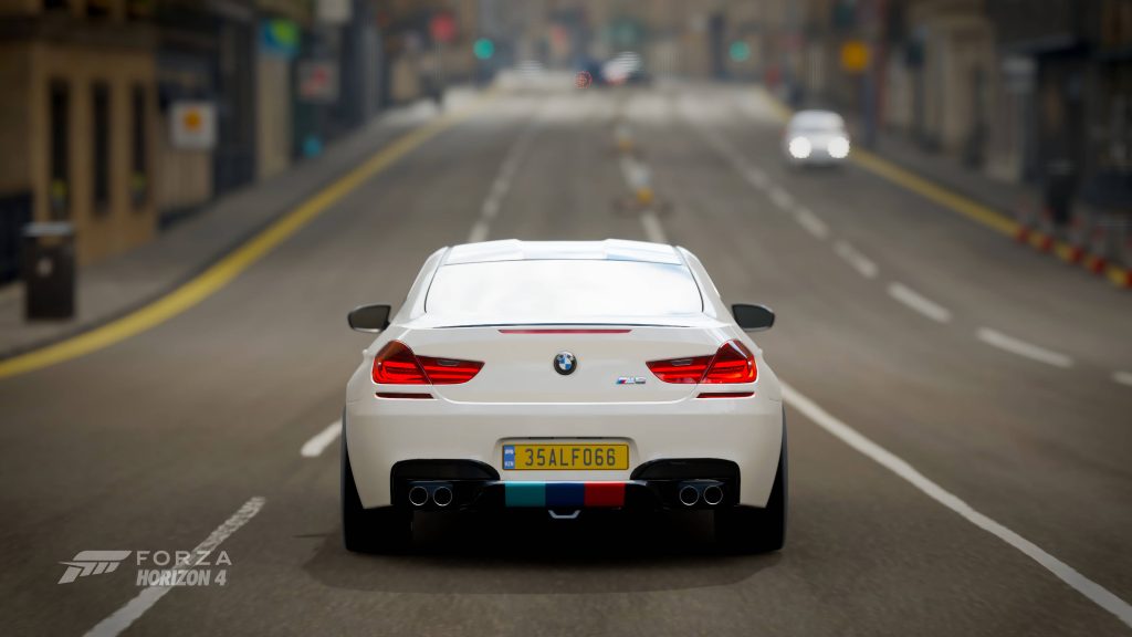 Rear view of white BMW M6 on city street Forza Horizon 4 CGI wallpaper high-performance coupe