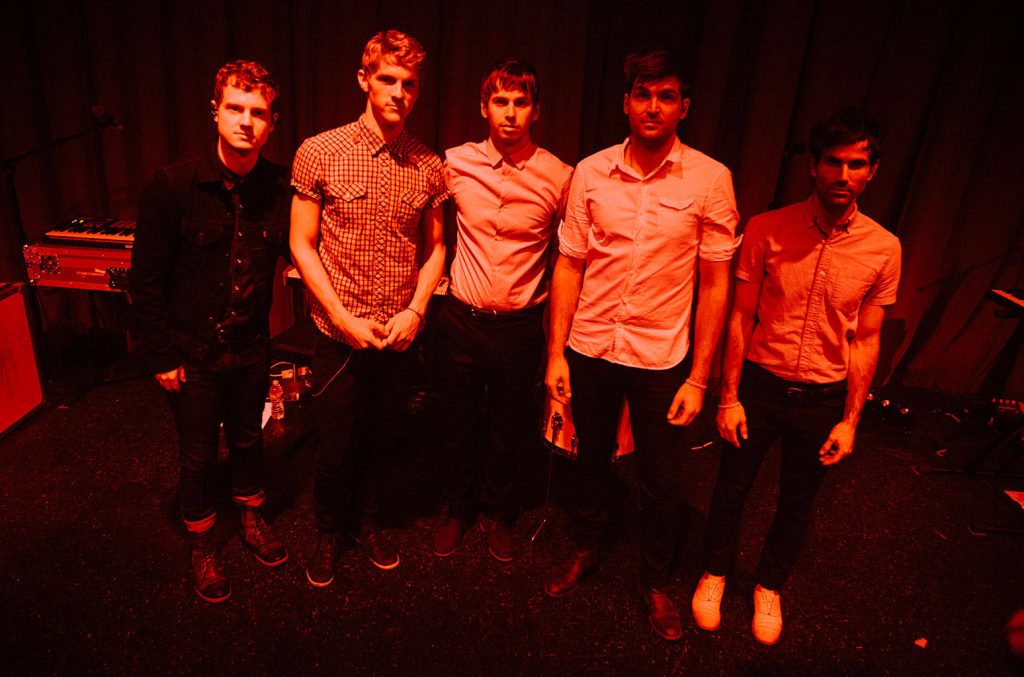 Foster the People backstage rock band wallpaper with red stage lighting and musical gear background