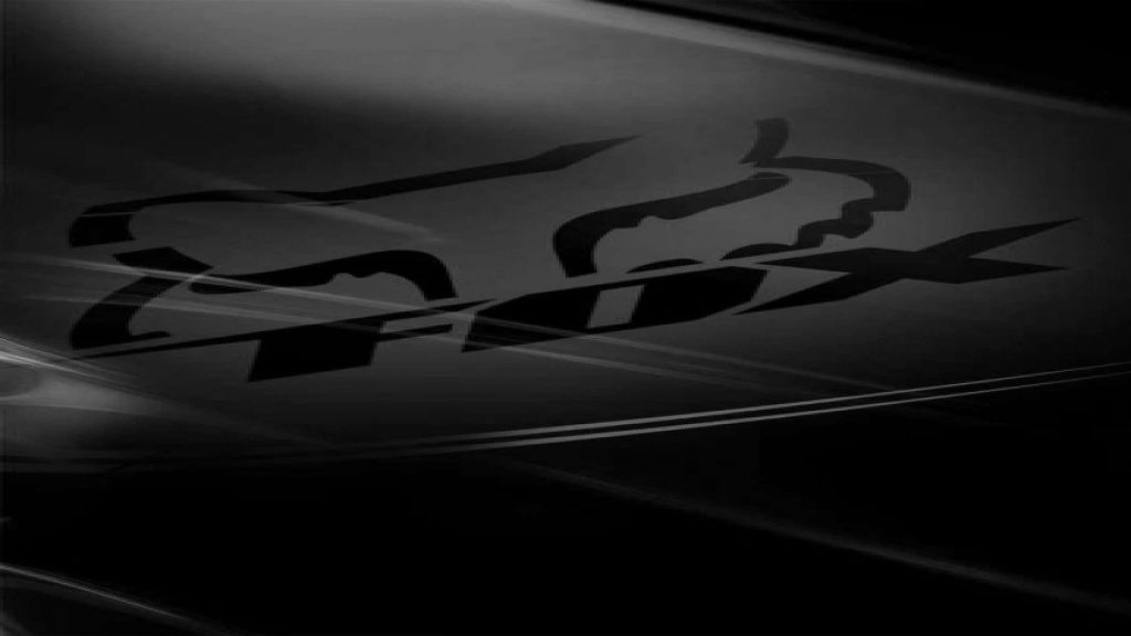 Fox Racing wallpaper with iconic logo on moody black abstract background for motocross fans