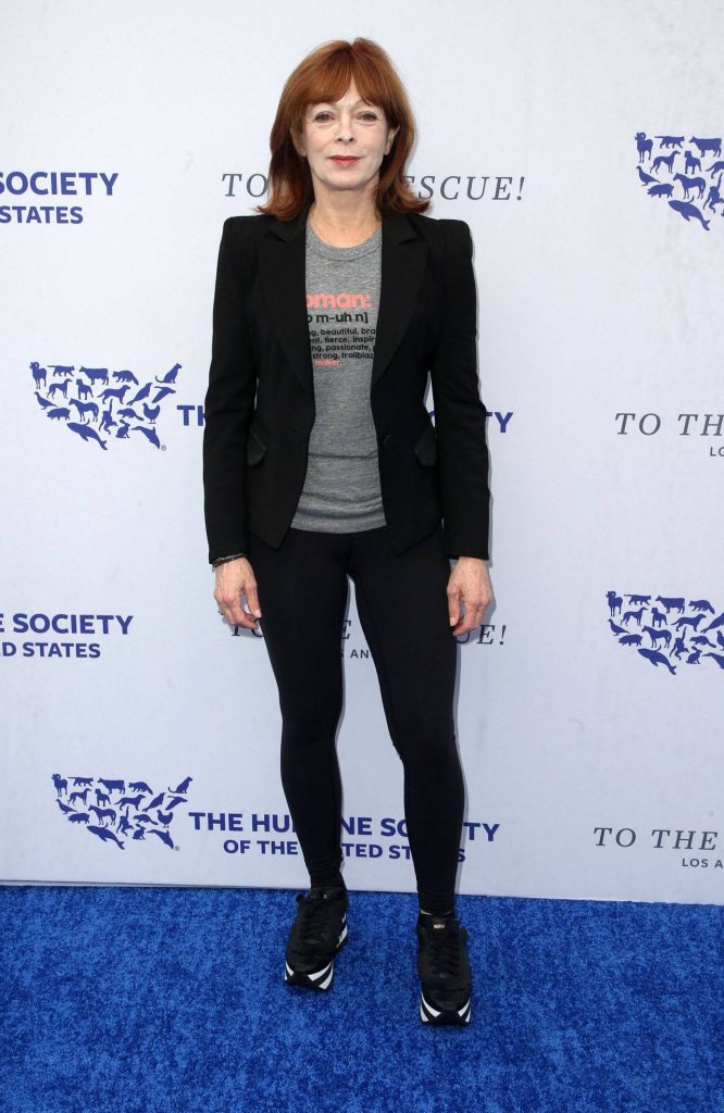 Actress Frances Fisher in black blazer and sneakers poses on blue carpet Humane Society event Wallpaper