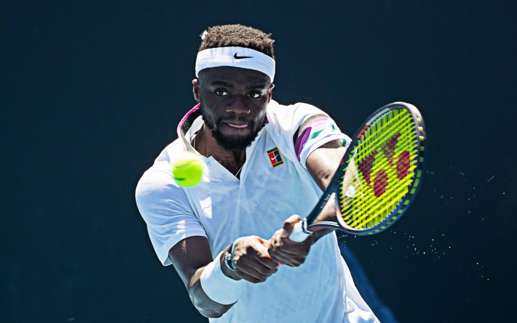 Frances Tiafoe powerful tennis groundstroke high-contrast action shot intense focus wallpaper