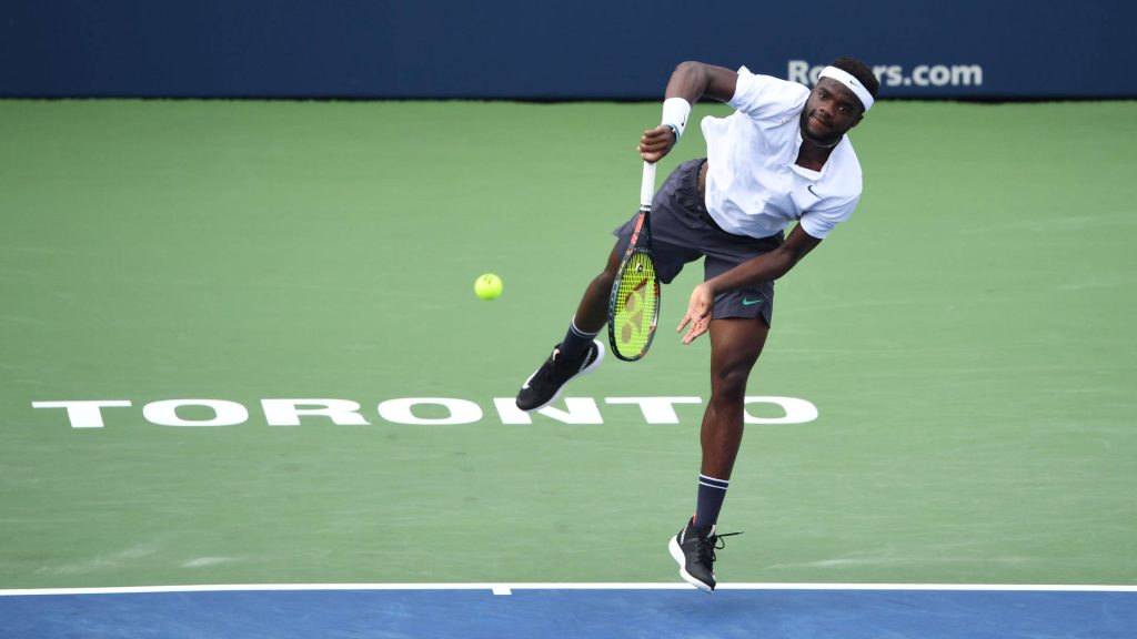 Frances Tiafoe powerful overhead serve on hard court Toronto intense tennis action wallpaper