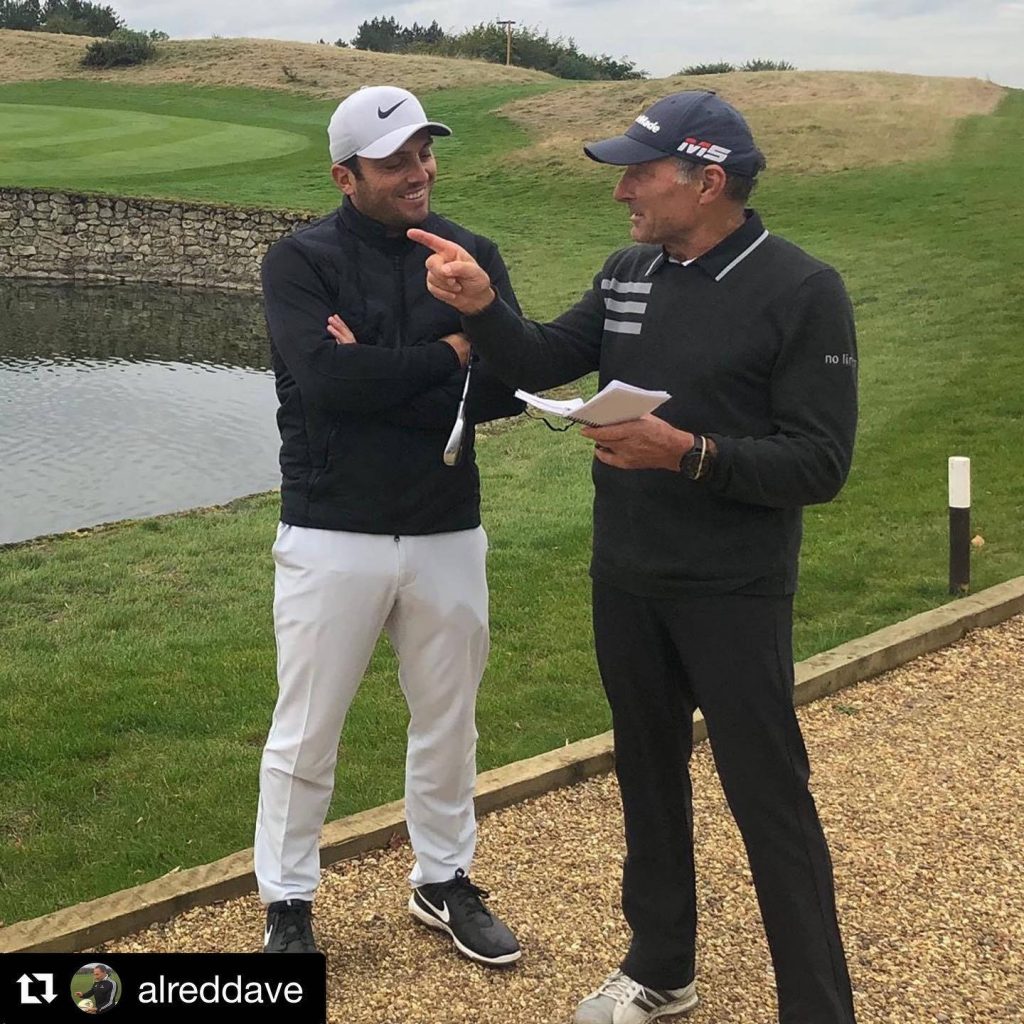 Pro golfer Francesco Molinari and coach Denis Pugh discuss golf technique by pond during training Wallpaper