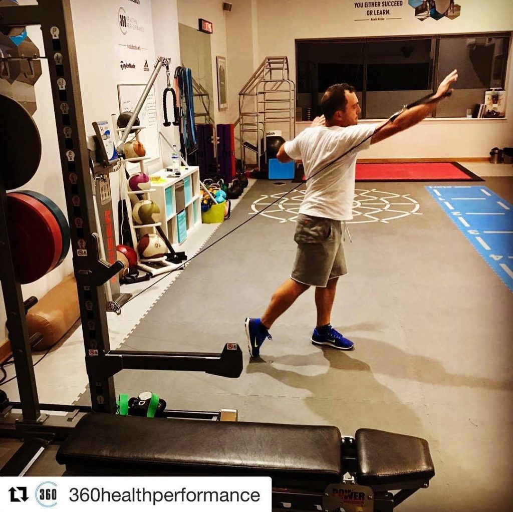 Francesco Molinari working out with resistance bands in a bright gym for golf fitness Wallpaper