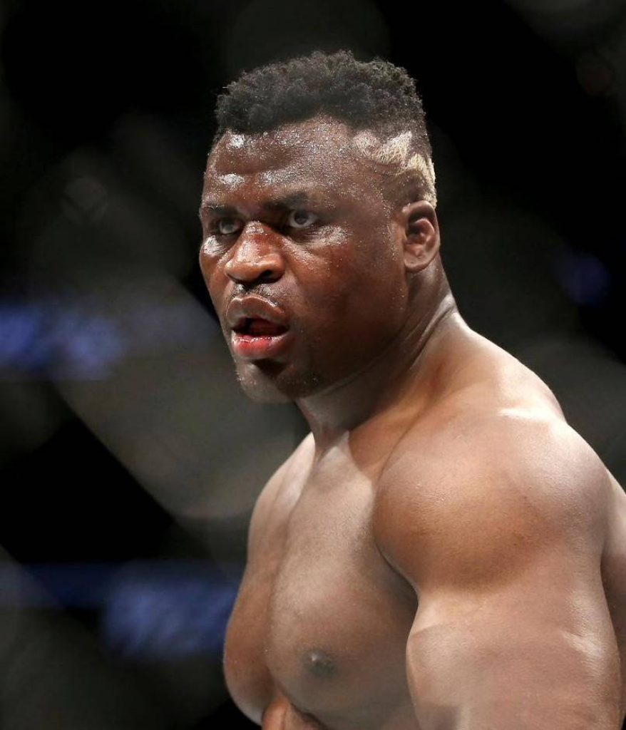 Francis Ngannou intense heavyweight fighter focused muscular physique arena lighting wallpaper