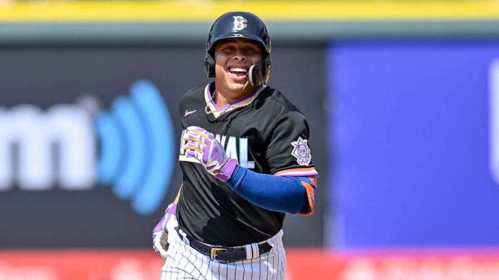 Francisco Alvarez smiling in black Mets uniform running under bright stadium lights baseball action Wallpaper