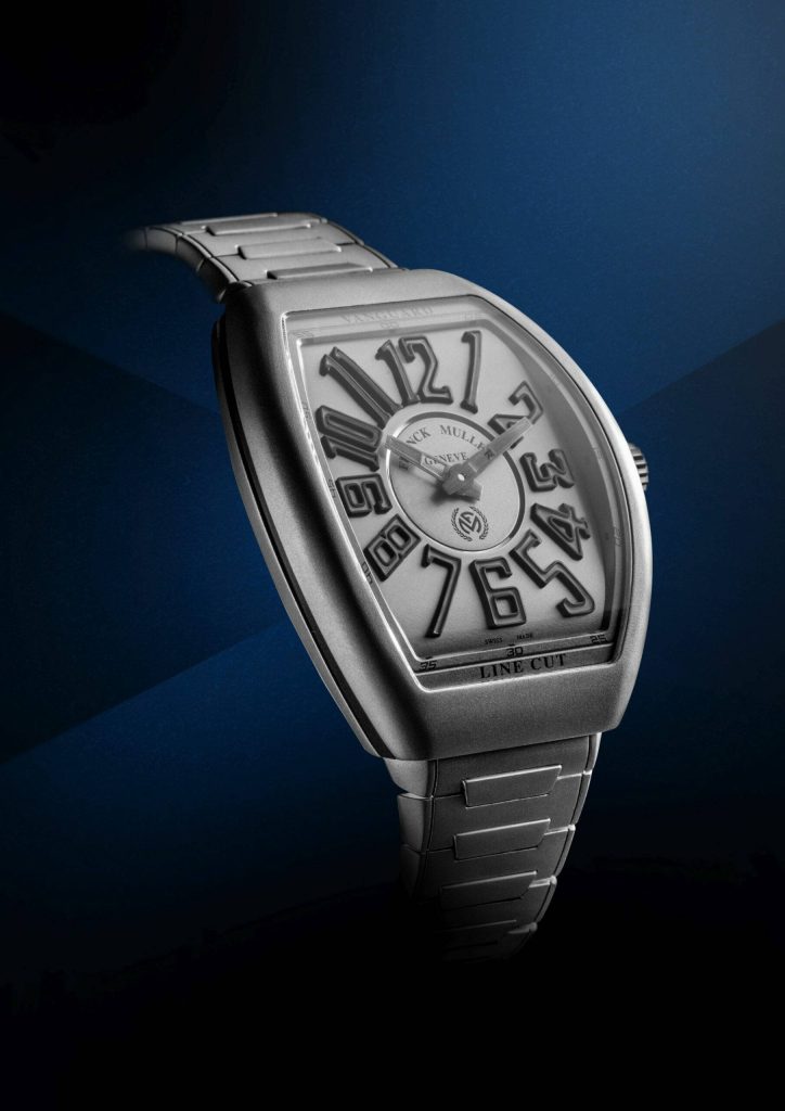 Franck Muller Vanguard Line Cut titanium watch side view with bold numerals on blue wallpaper