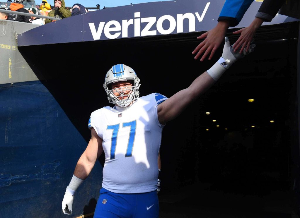 Detroit Lions center Frank Ragnow high-fives fans wearing white No 77 uniform game day wallpaper