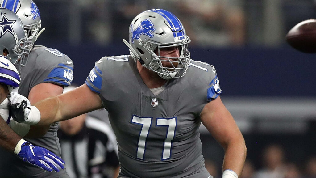 Frank Ragnow in Detroit Lions grey jersey number 77 showing intensity during NFL game action Wallpaper