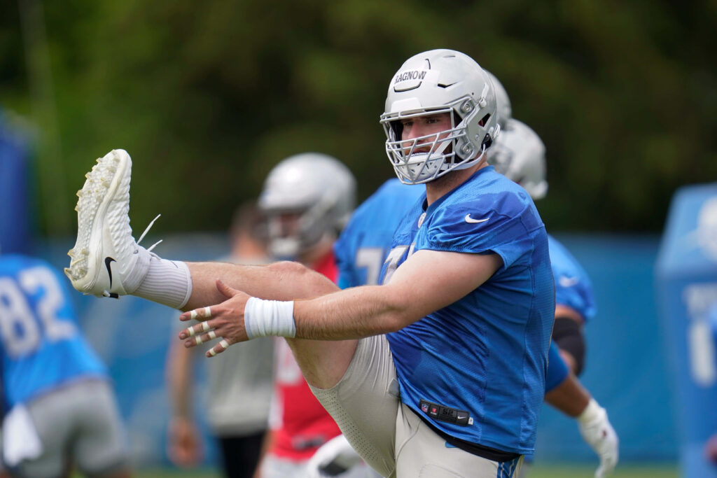 Frank Ragnow Detroit Lions No 77 stretching on field in blue silver practice gear outdoors Wallpaper