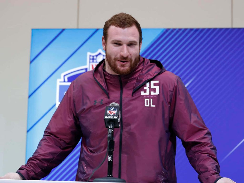 Frank Ragnow NFL Combine press conference in maroon Under Armour jacket speaking into microphone Wallpaper