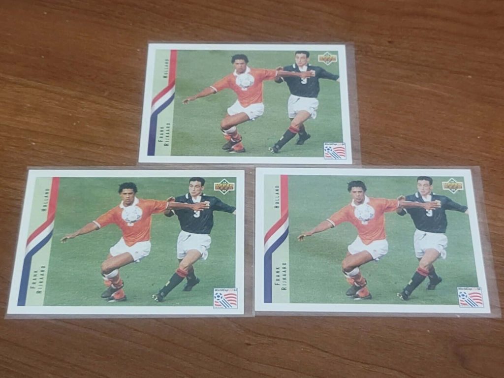 Three Upper Deck 1994 World Cup Frank Rijkaard trading cards on wooden surface wallpaper