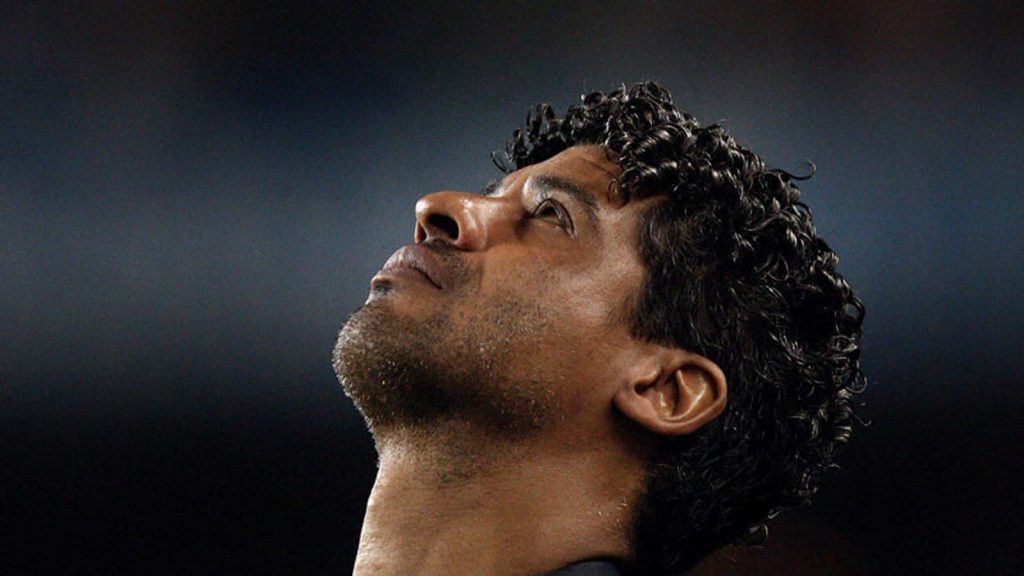 Frank Rijkaard close-up with curly hair intense gaze dark background football legend wallpaper