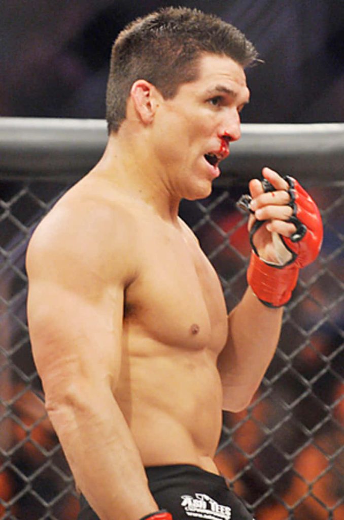 Frank Shamrock intense MMA fighter with red gloves and bloody nose in octagon cage background Wallpaper