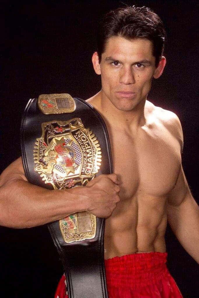 Frank Shamrock MMA legend holding UFC Middleweight Championship belt in dramatic studio portrait Wallpaper