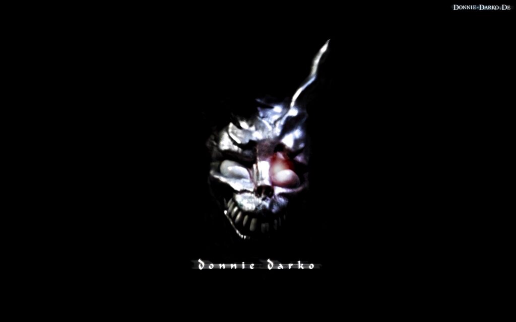 Haunting Frank the Rabbit wallpaper with glowing eyes and eerie metallic mask on black background