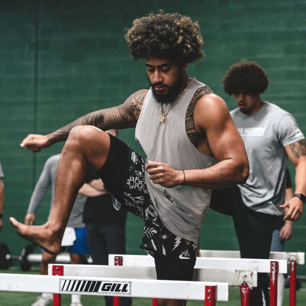 Frankie Luvu NFL linebacker intense hurdle training indoor gym green walls athletic tattoos Wallpaper