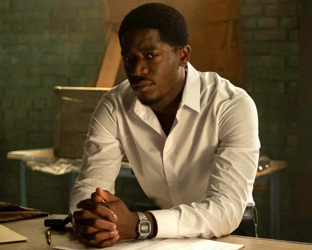 Franklin Saint in white shirt at desk with warm industrial brick background Snowfall wallpaper