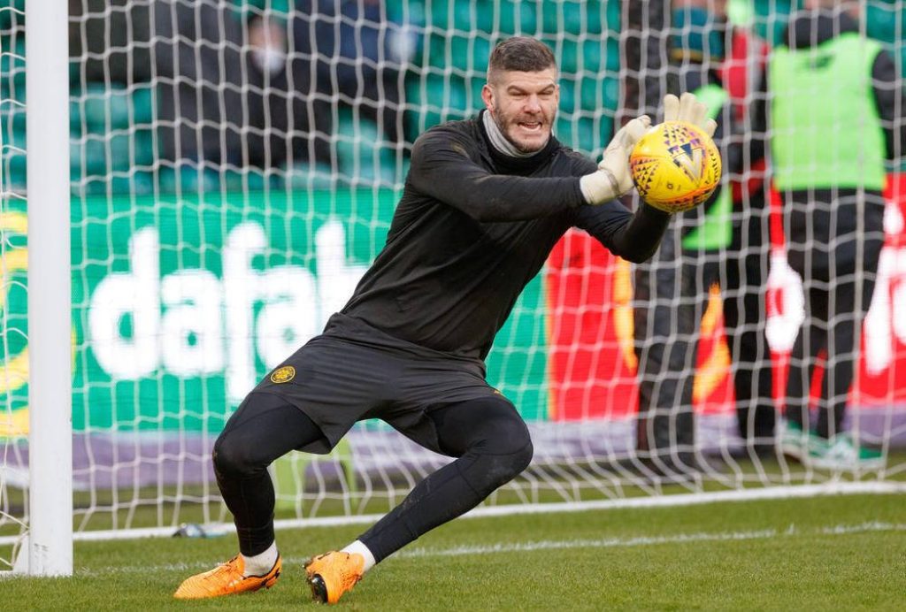 Goalkeeper Fraser Forster in black kit makes an athletic save blocking football at goal net Wallpaper