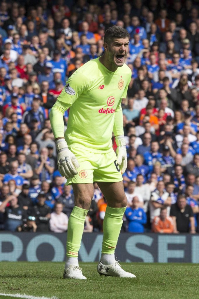 Celtic goalkeeper Fraser Forster in neon green kit shouting on pitch with blurred stadium crowd background Wallpaper