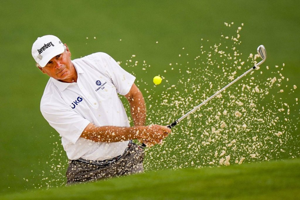Fred Couples golf bunker shot with sand spray on lush green course high-resolution wallpaper